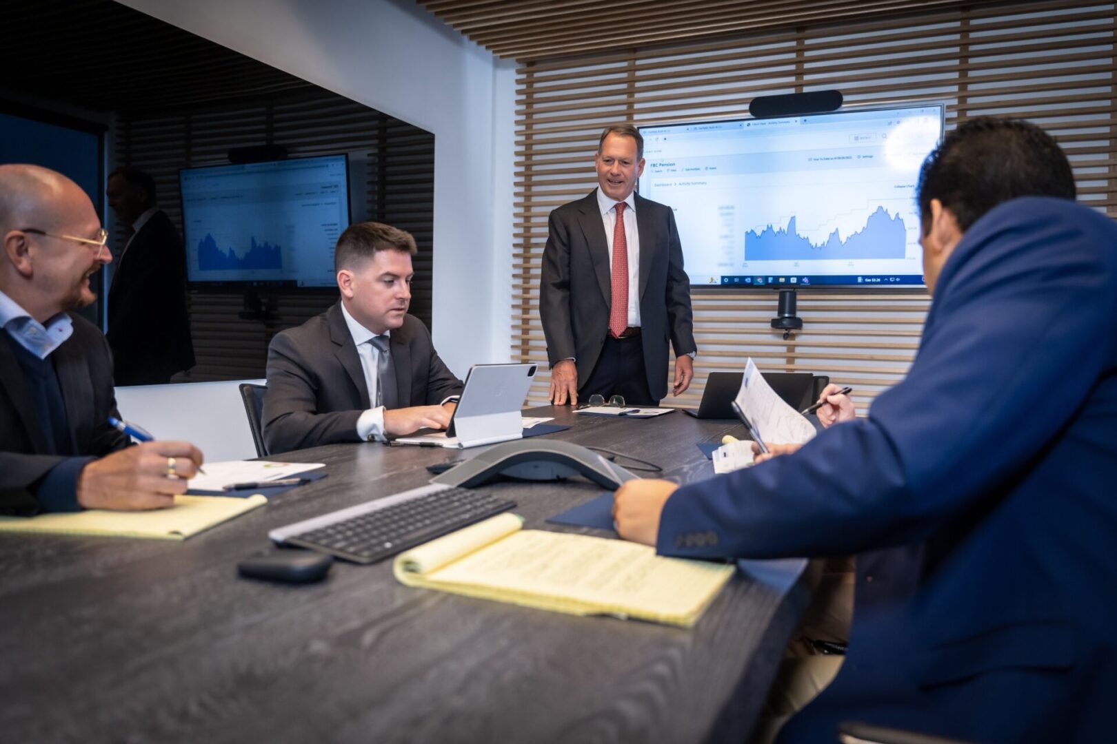 A group of people in suits sitting at a table.